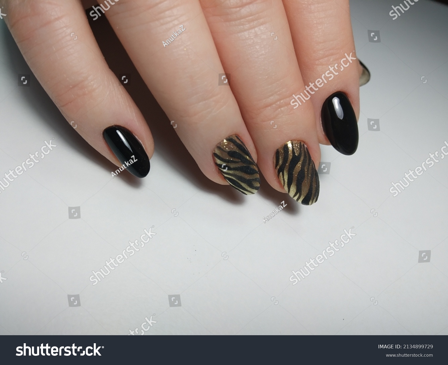 Black and gold zebra nails manicure gel-laque on white background