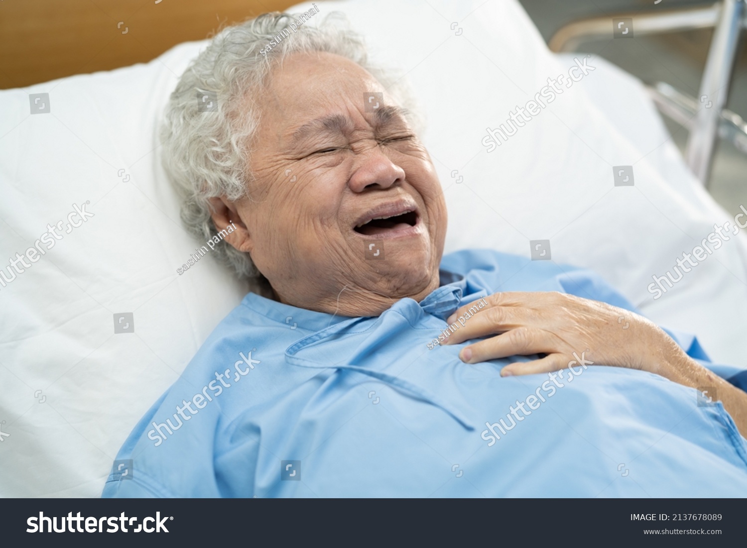 Asian senior or elderly old lady woman patient feel pain in the chest and heart on bed in nursing hospital ward; healthy strong medical concept.