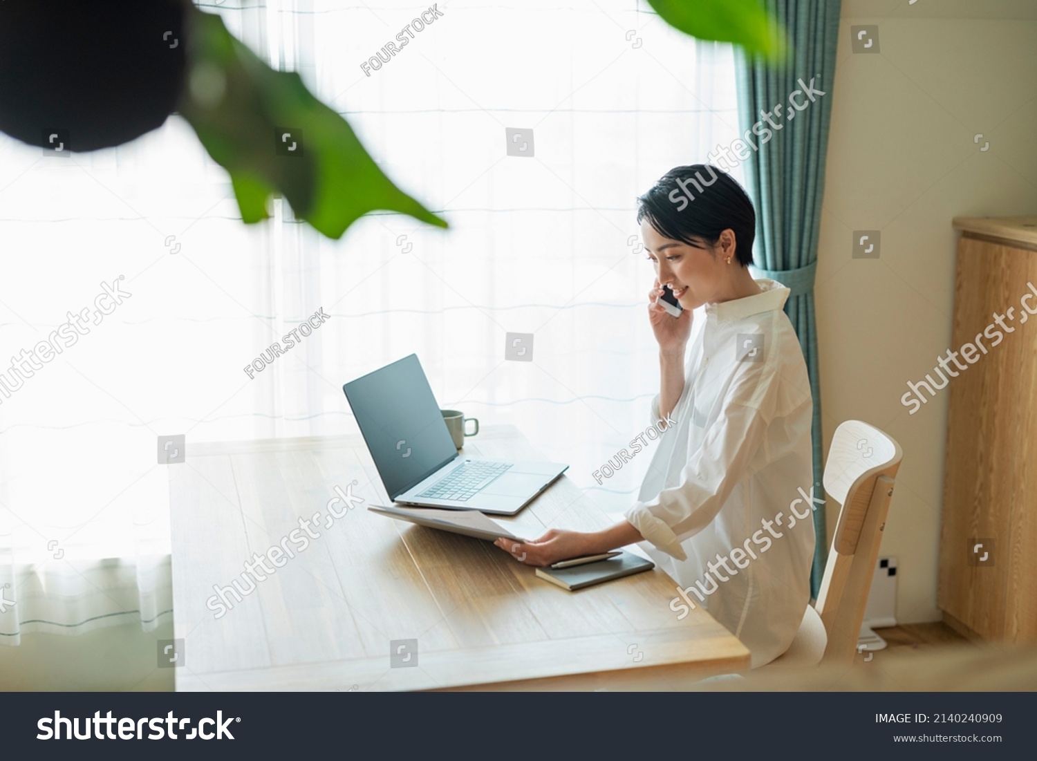 Woman making a phone call while working remotely