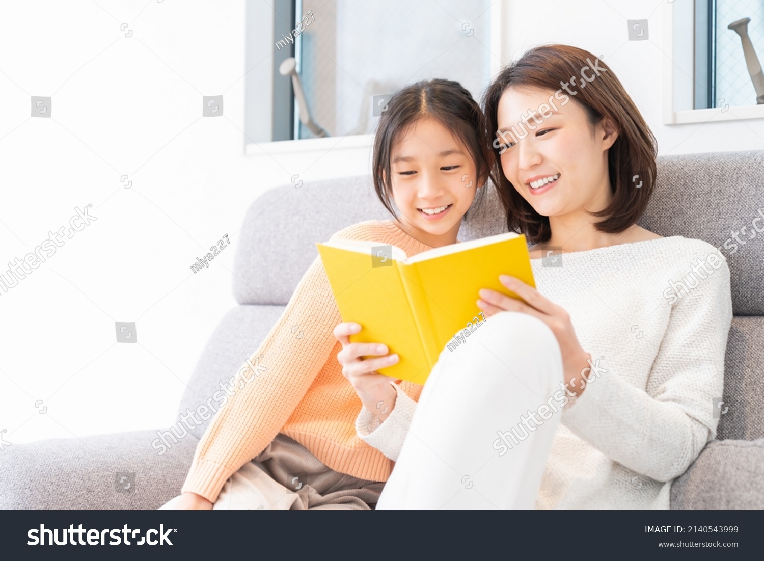  asian parent and daughter who reads a book