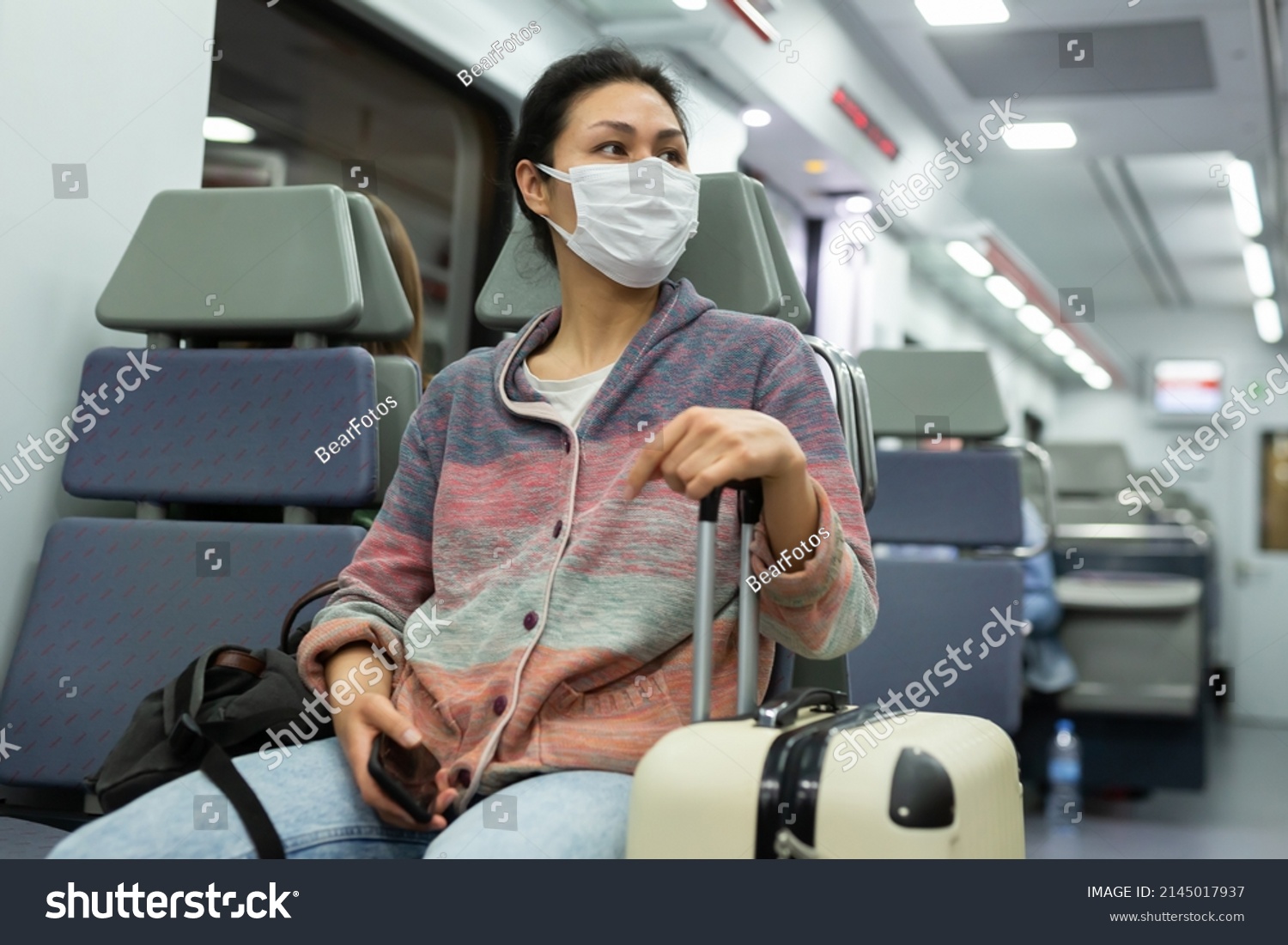 Asian woman in protective mask sitting in subway train
