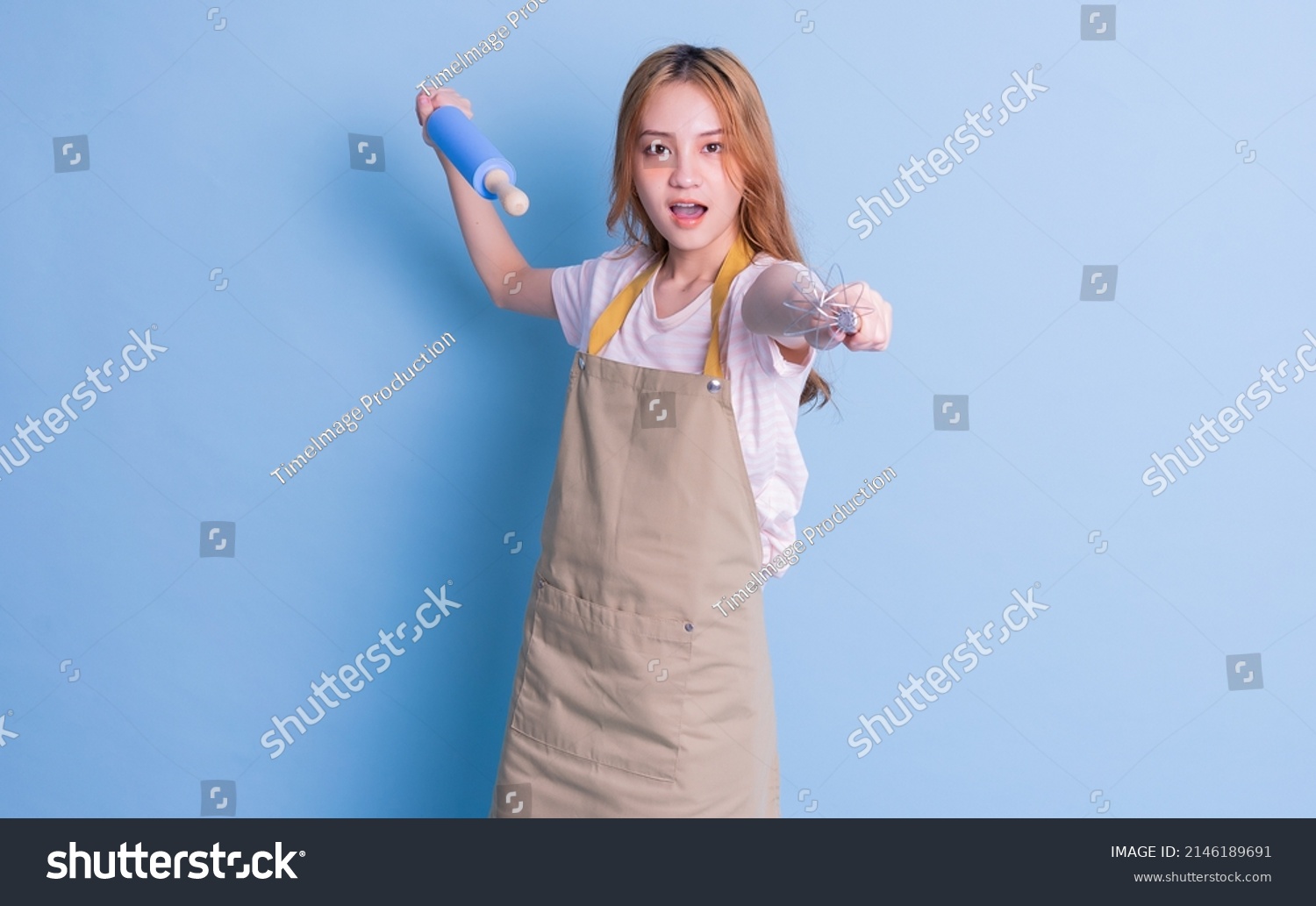 Portrait of housewife posing on blue background