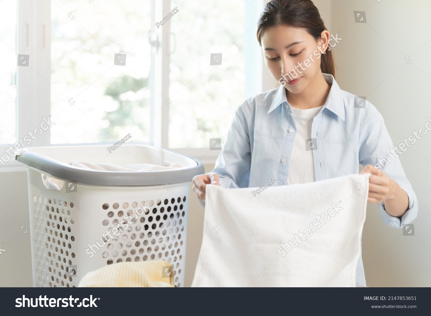 Laundry household work concept  asian woman working on fresh clean clothes.