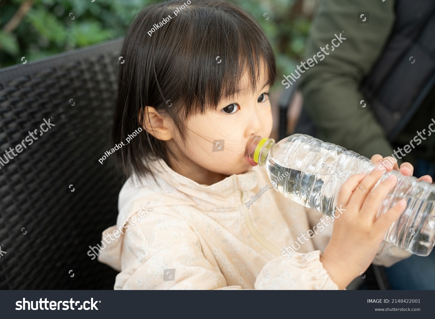 Asian child drinking water from a plastic bottle