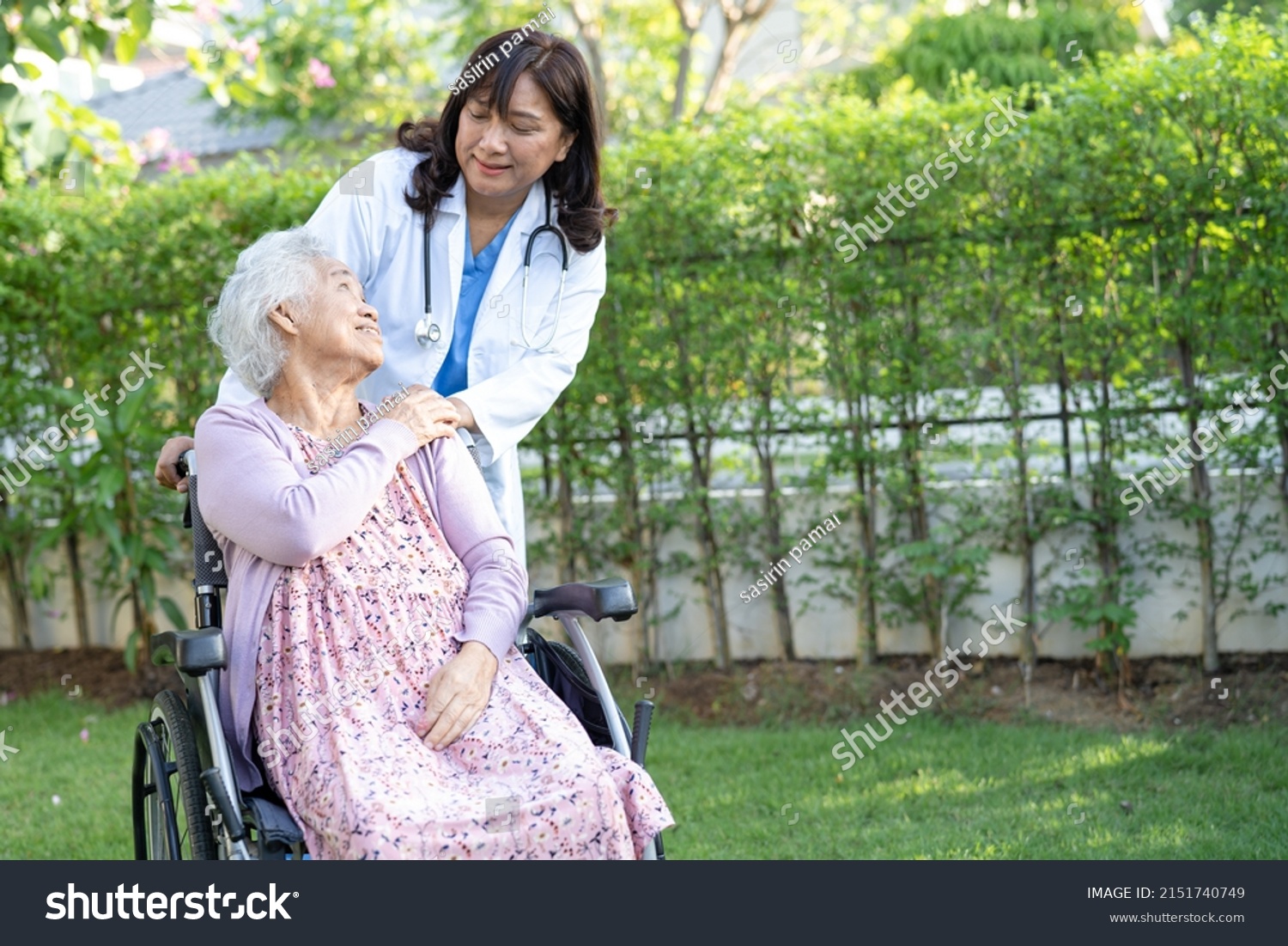 Doctor help and care Asian senior or elderly old lady woman patient sitting on wheelchair at park in nursing hospital ward healthy strong medical concept.