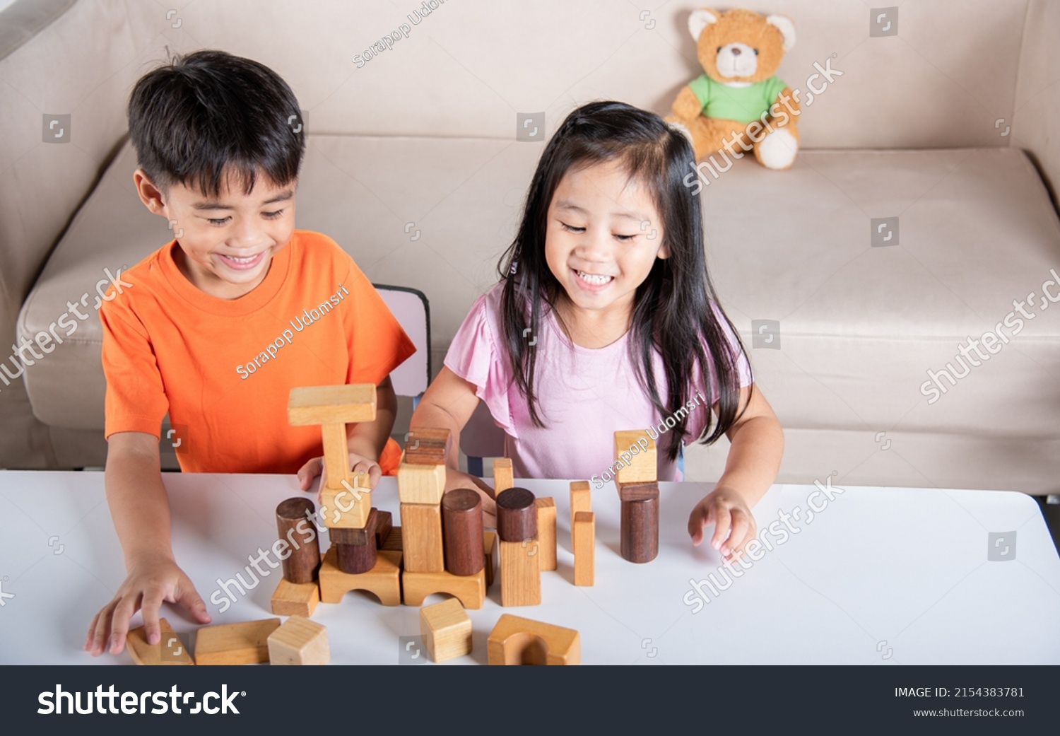 Children boy and girl playing with constructor wooden block building  Happy little kids play wood block stacking board game at home  activities learning creative  toys for preschool and kindergarten