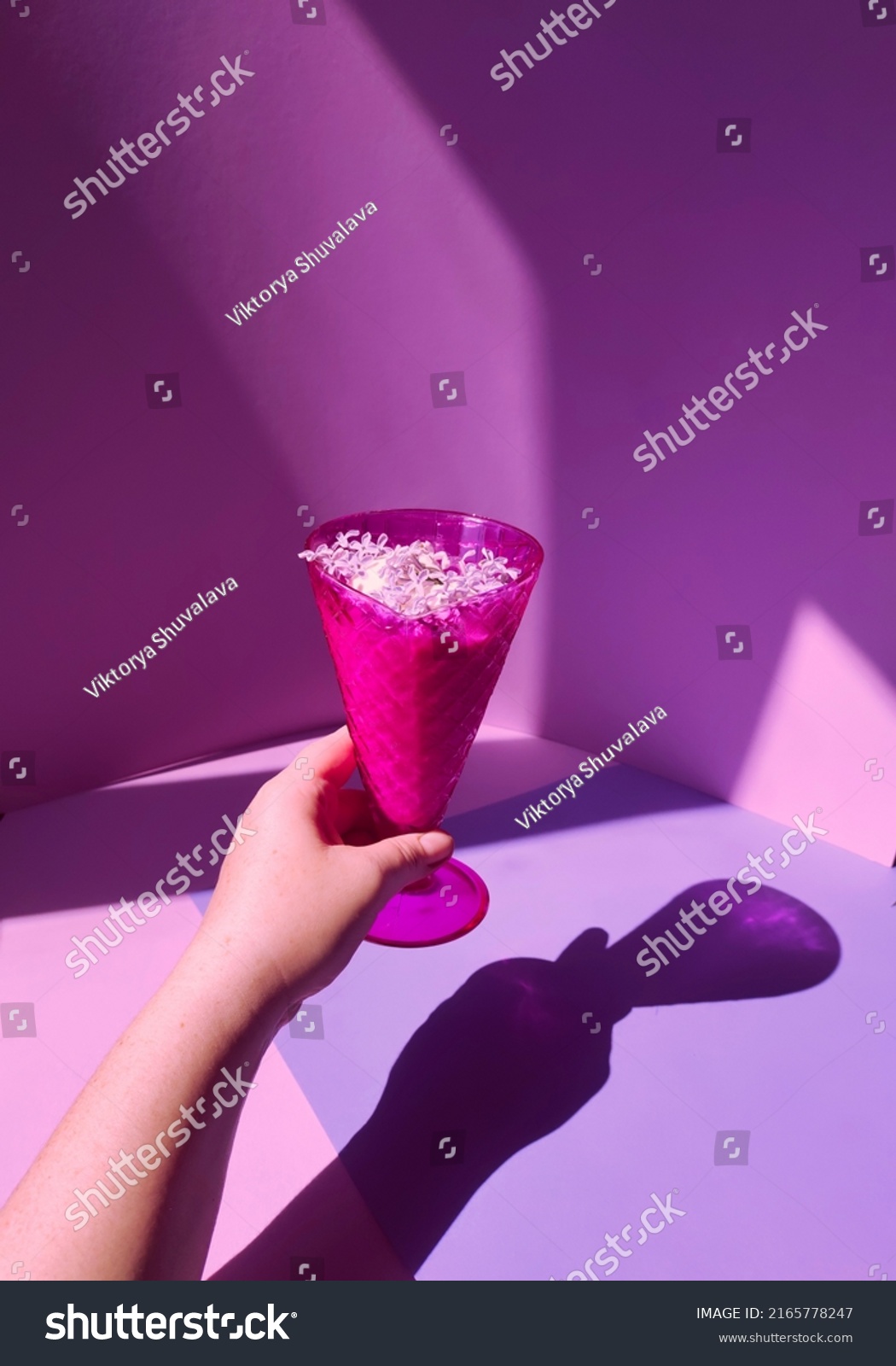 dessert of ice cream in a purple vase with lilac flowers. in the hands of a woman  a cream bowl with ice cream. 