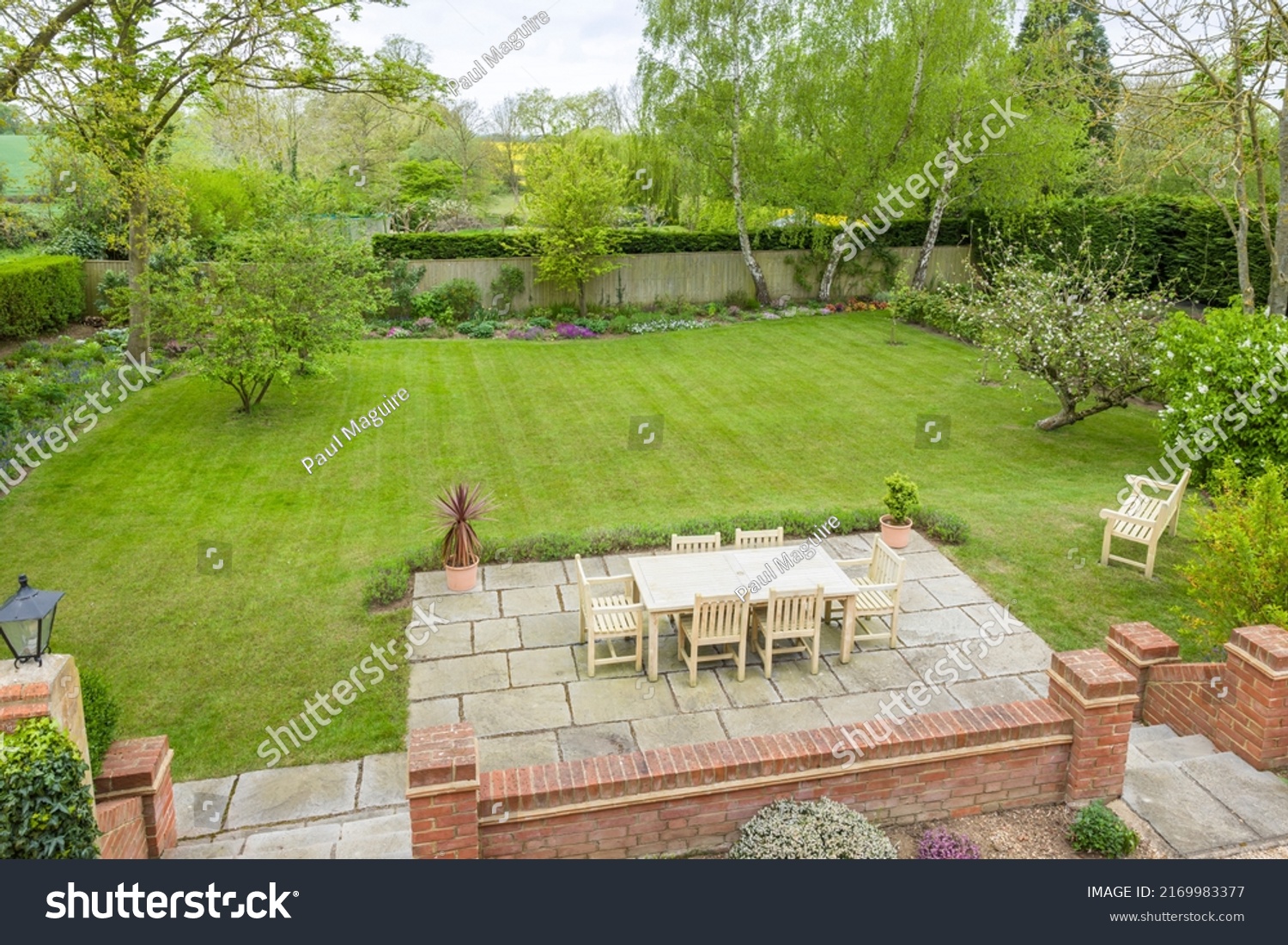 Wooden garden furniture on a patio terrace in a UK landscaped back