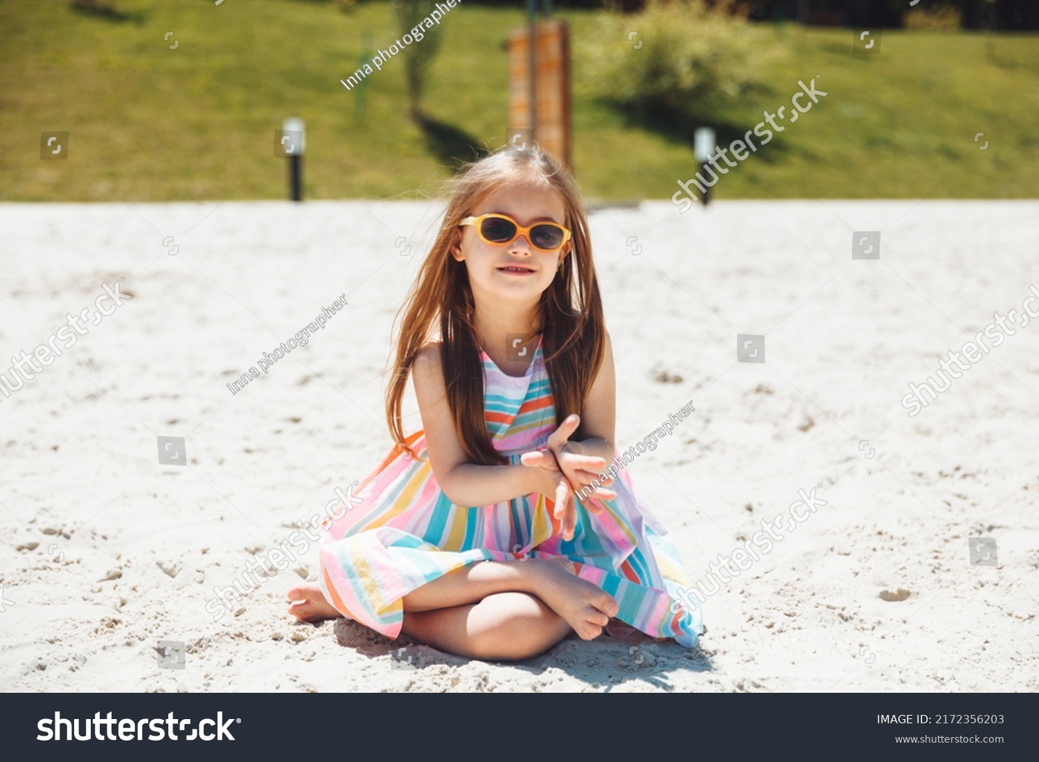 cheerful little girl with down syndrome in a summer hat on the beach.
