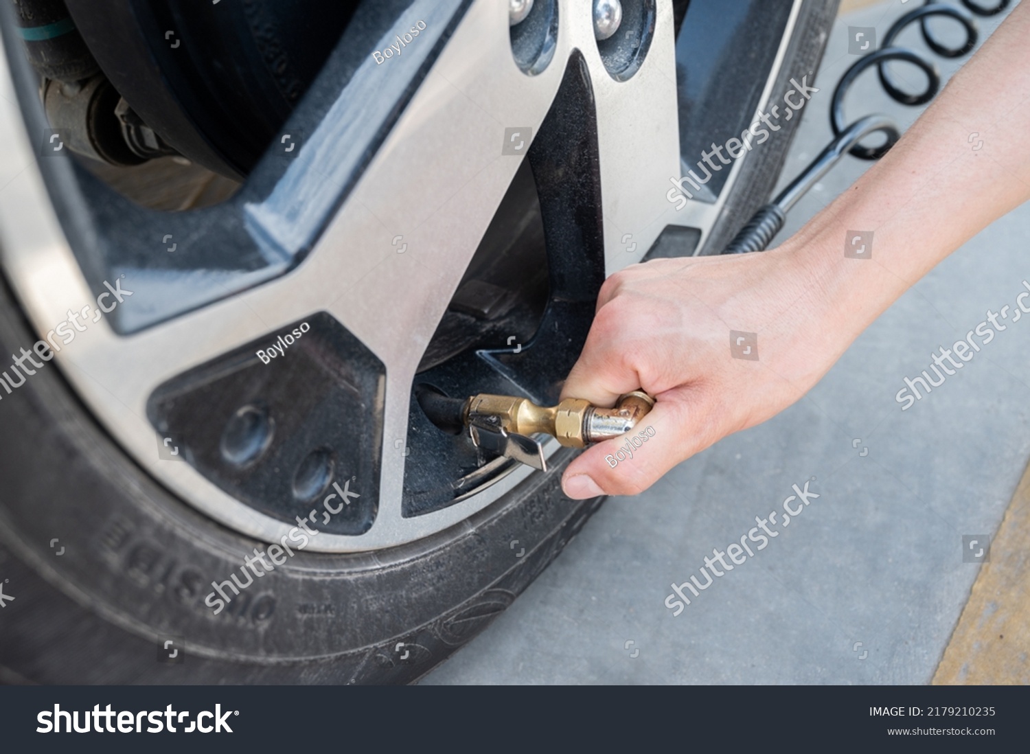 Someone hand inflating car tire. To add air to your tyres simply insert
