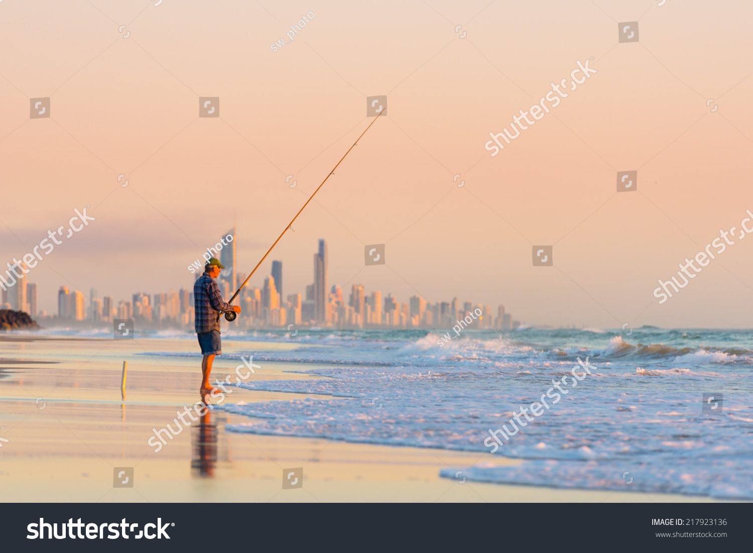 Fisherman fishing at sunrise on the Gold Coast with Surfers Paradise in the background.