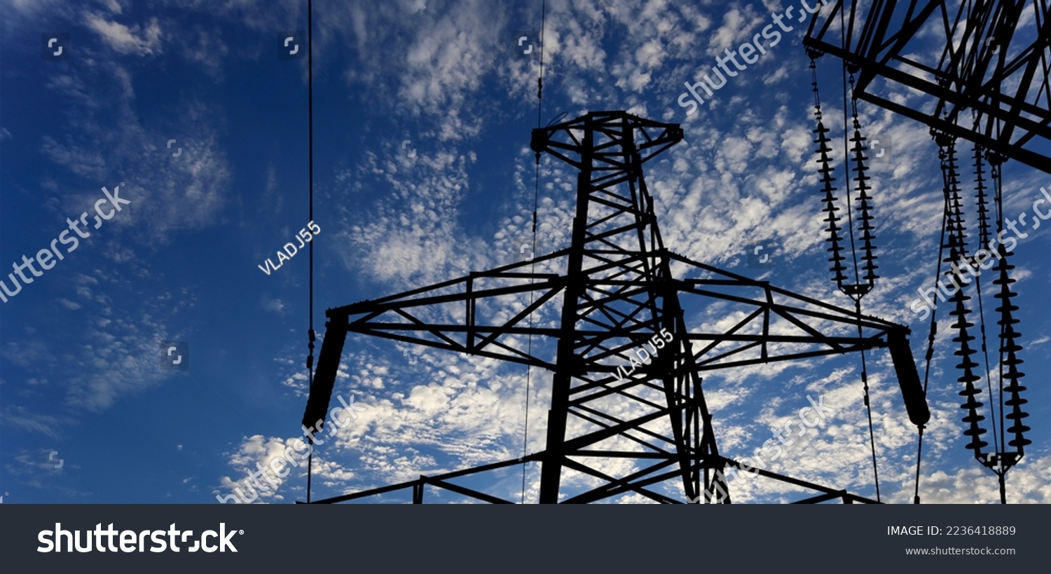 Electricity pylon (high voltage power line) black contour on the background of the cloudy sky