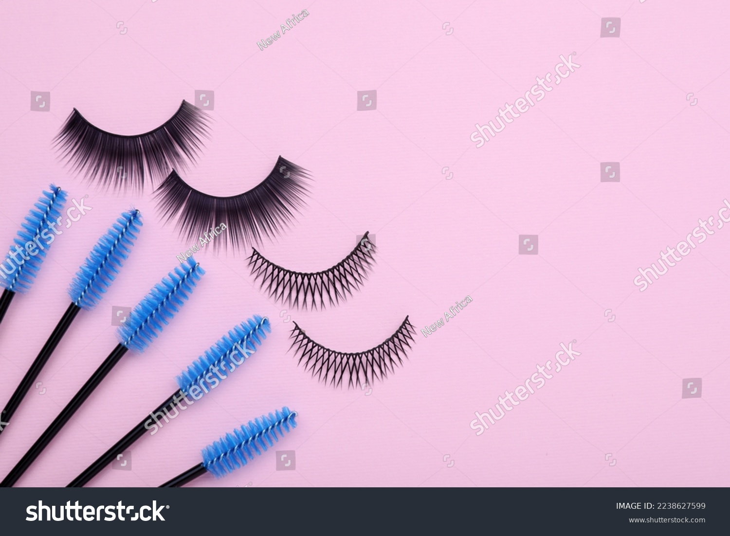 Fake eyelashes and brushes on pink background  flat lay. Space for text