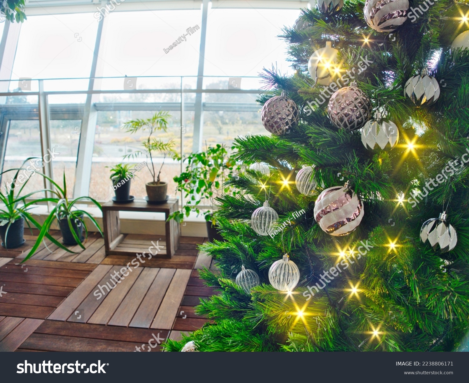 Twinkling Christmas tree lights with ornaments and a bright window for background