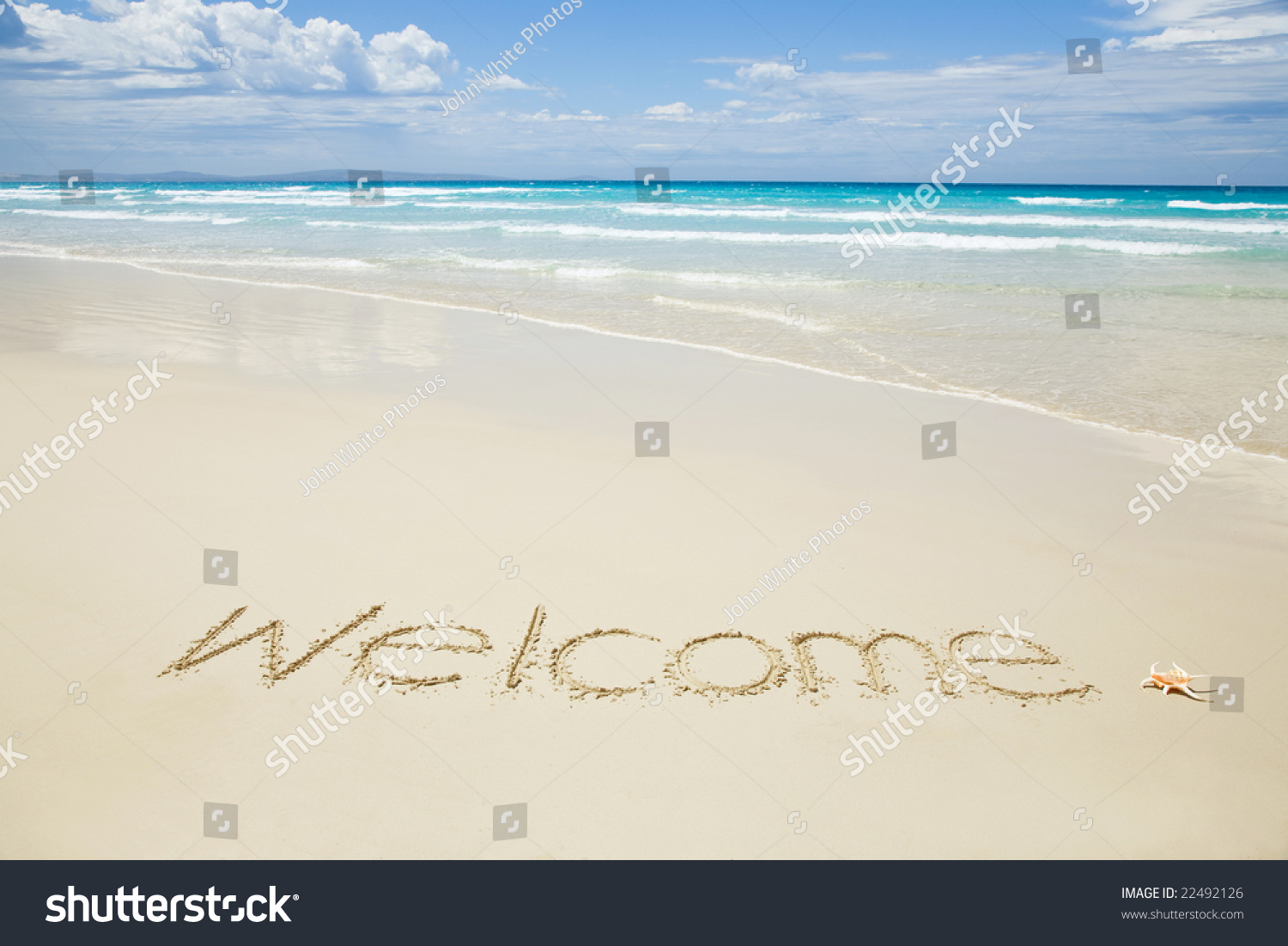 Welcome written on a tropical beach