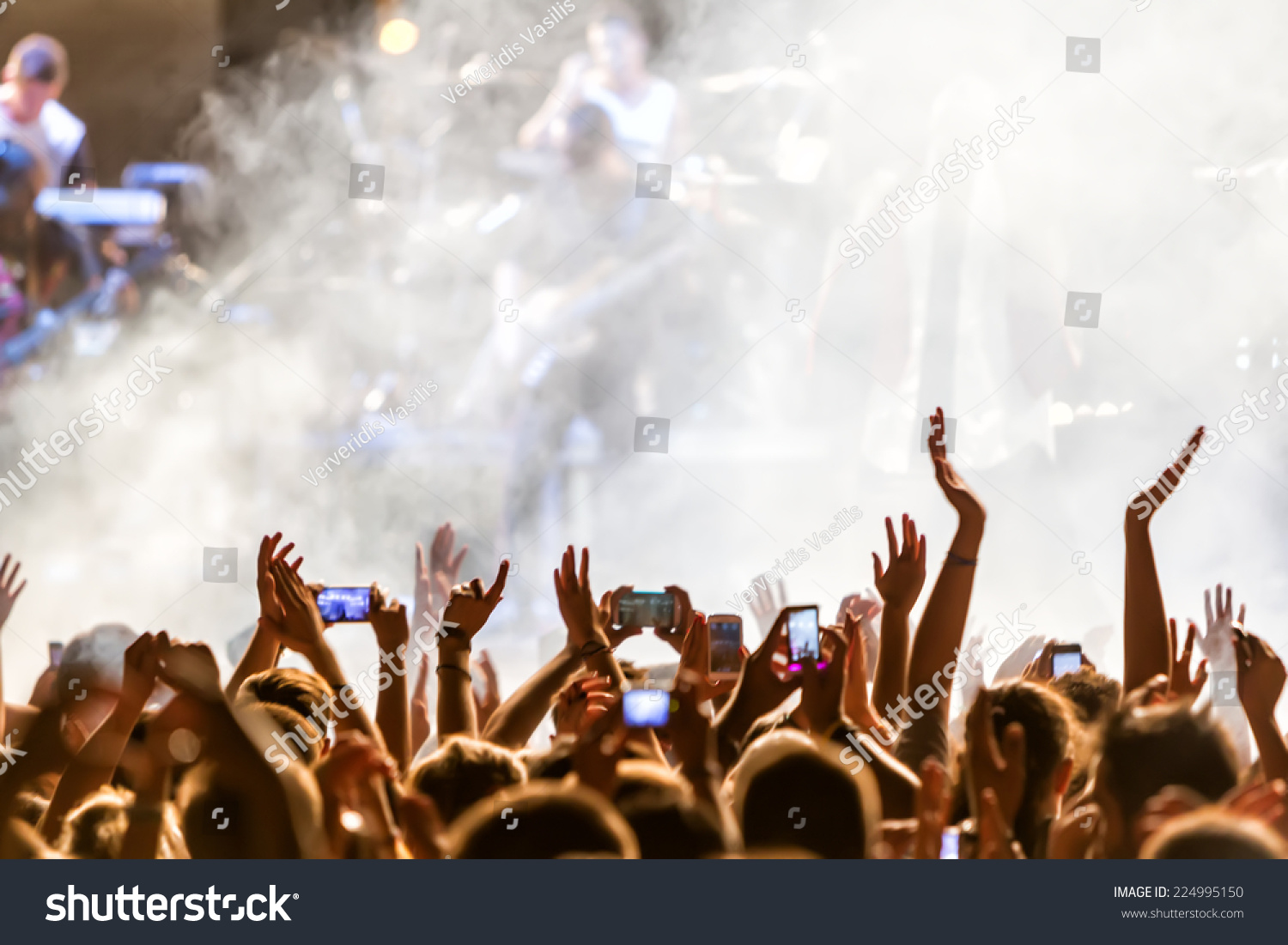 People taking photographs with touch smart phone during a music entertainment public concert