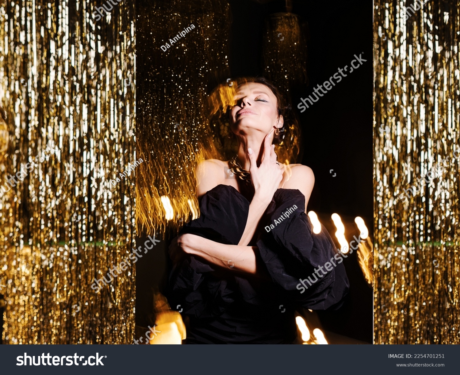 Stylish student girl dancing in a nightclub. Holiday atmosphere. Black and gold trend. Disco party. Attractive glamor sexy young woman. Night life emotions. Birthday celebrations. small black dress.