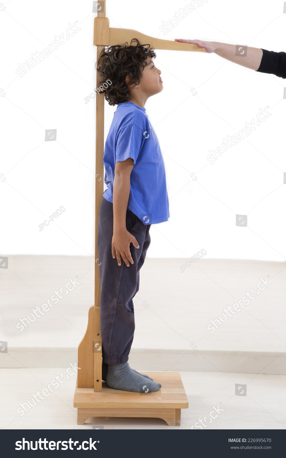 Doctor measures growth smiling boy in medical office profile view_站酷海洛 ...