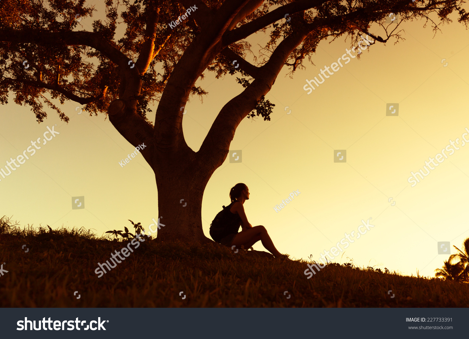 Hiker woman with backpack enjoying beautiful sunset