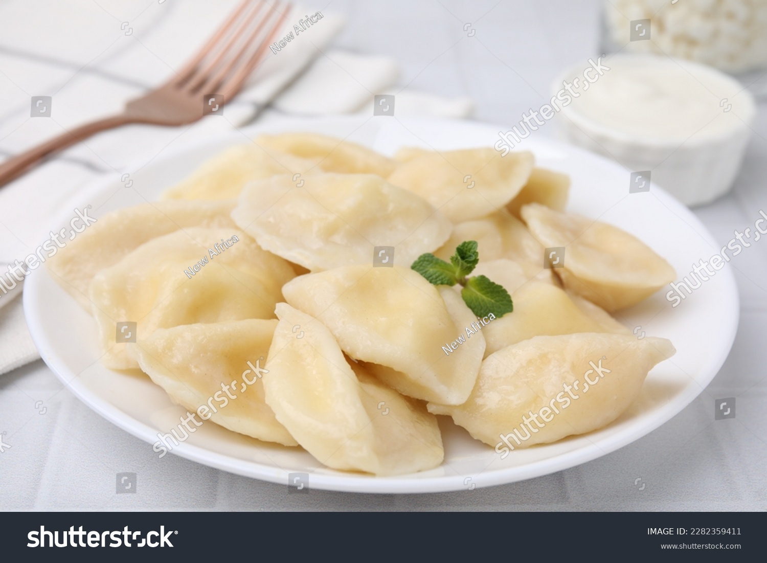 Plate of delicious dumplings (varenyky) with cottage cheese on white table  closeup
