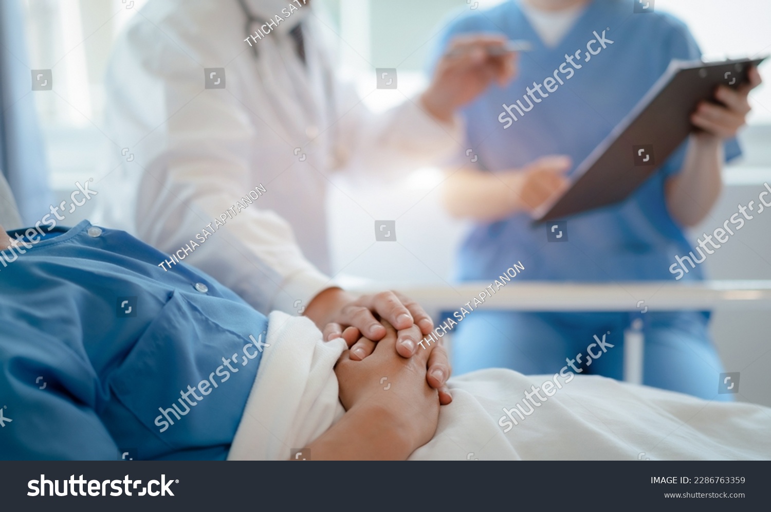 doctor talking with man patient for monitoring and check up after surgery. doctor touching patient hand and consoling.