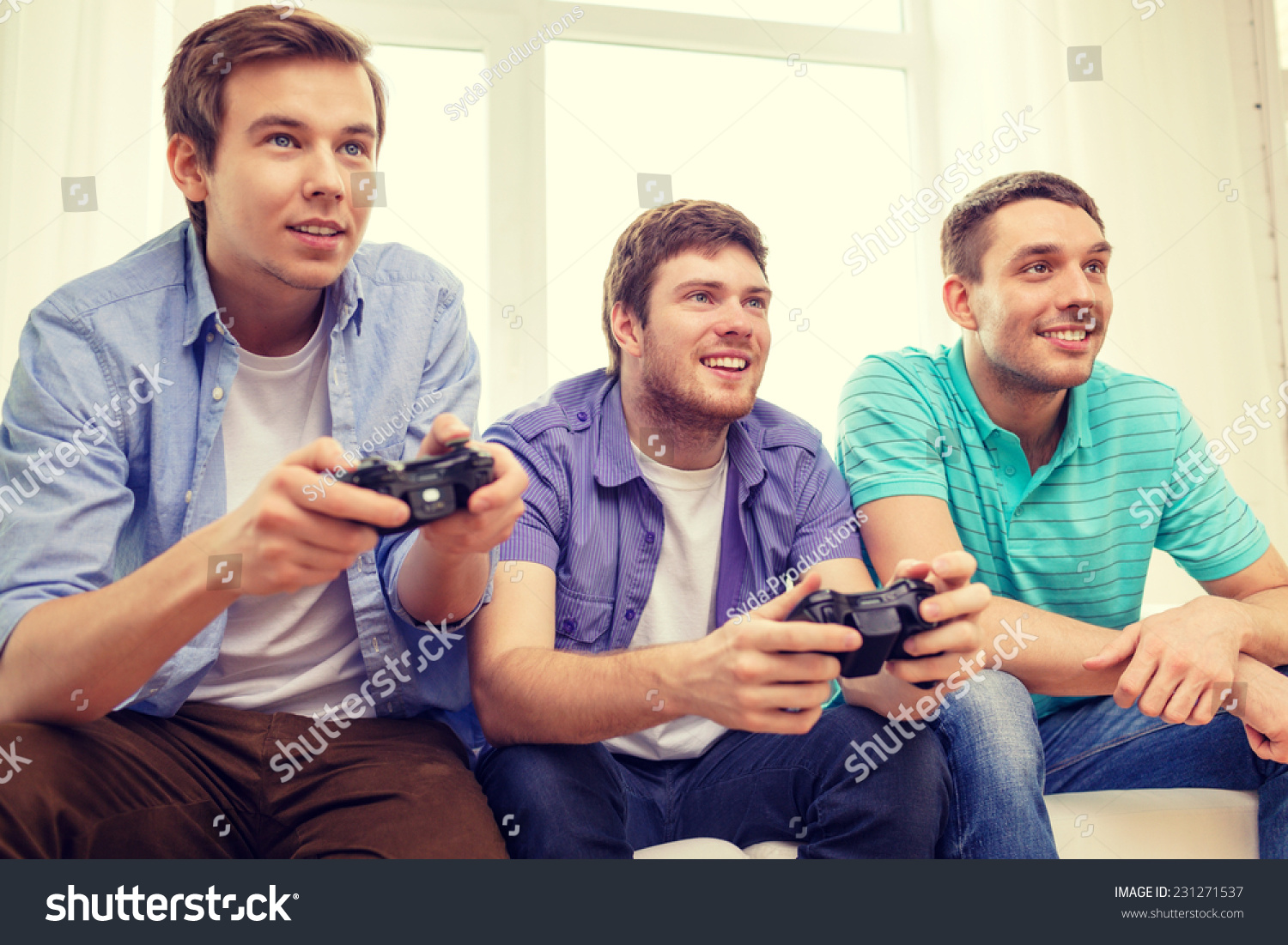 friendship  technology  games and home concept - smiling male friends playing video games at home
