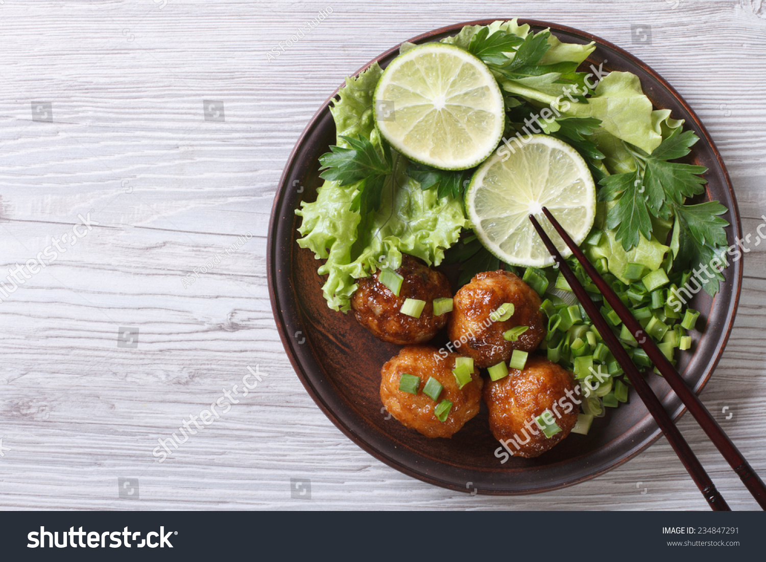 Fish balls in curry sauce on a plate with fresh herbs. top view of a horizontal 