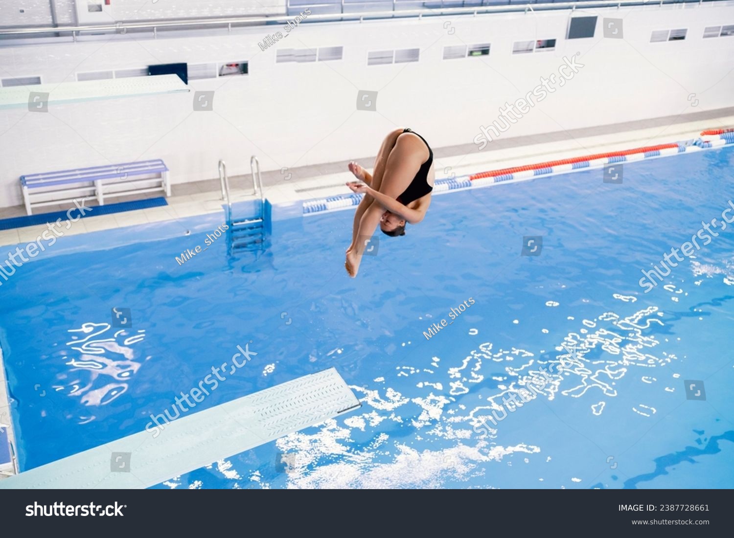 olympic sport  sports diving in the swimming pool  female athlete doing spin in the air