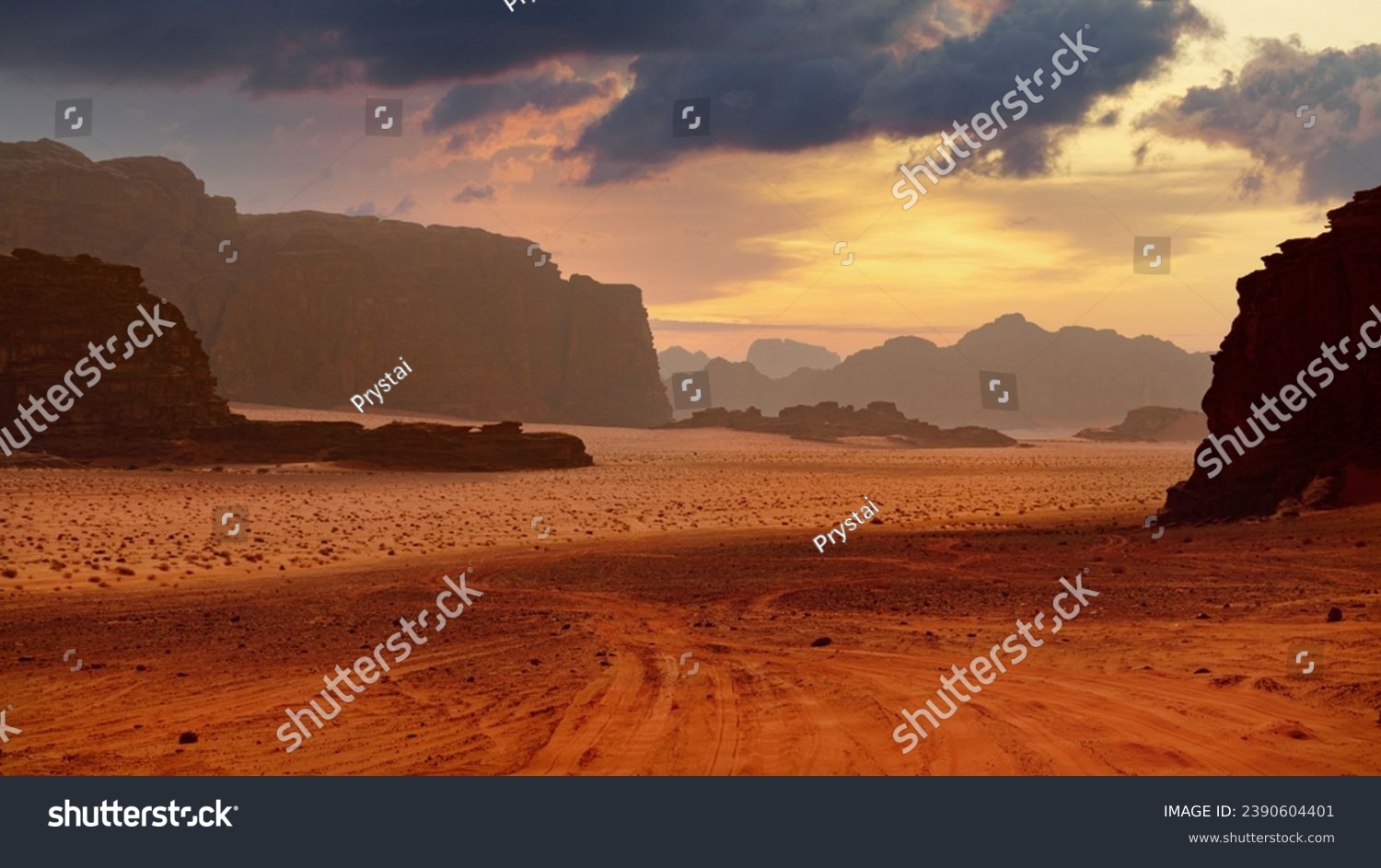 Sunset over a desert with rock formations and scattered clouds. Dramatic sky. Panoramic wallpaper of Wadi Rum desert  Jordan.