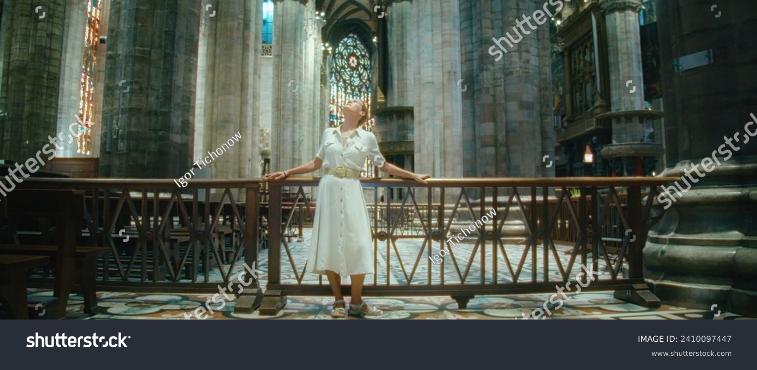 Woman traveler looking at ancient architecture of Basilica. Girl visiting historical sights while traveling.