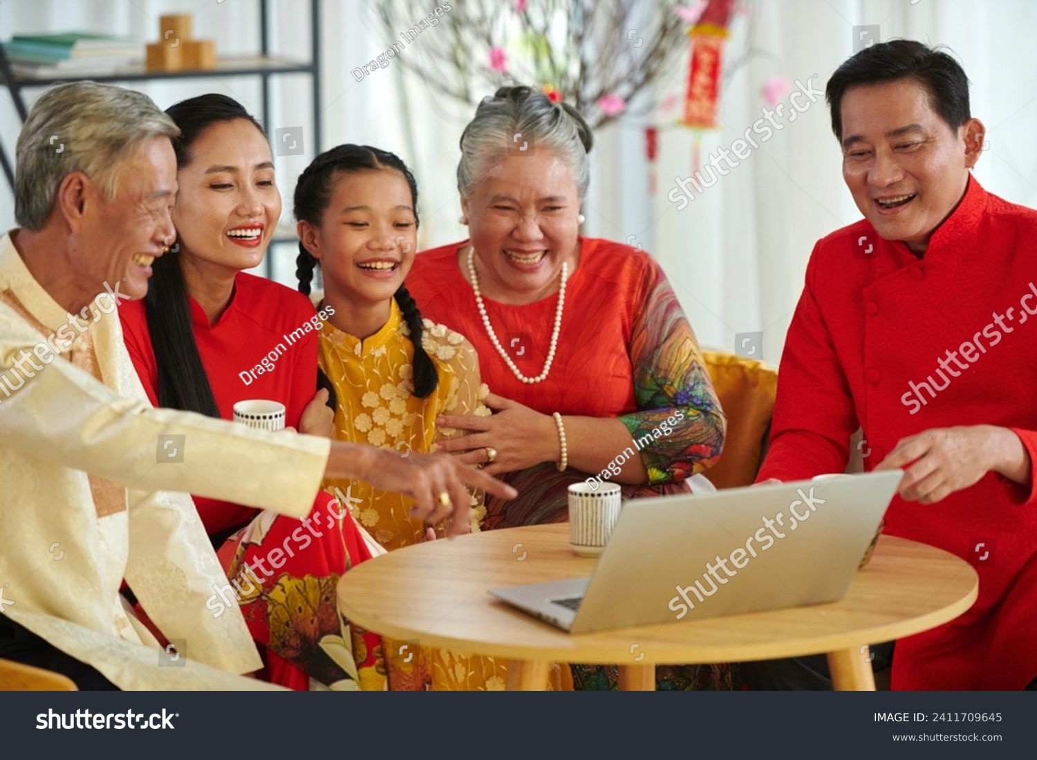 Big family watching comedy movie and drinking tea when spending Lunar New Year at home