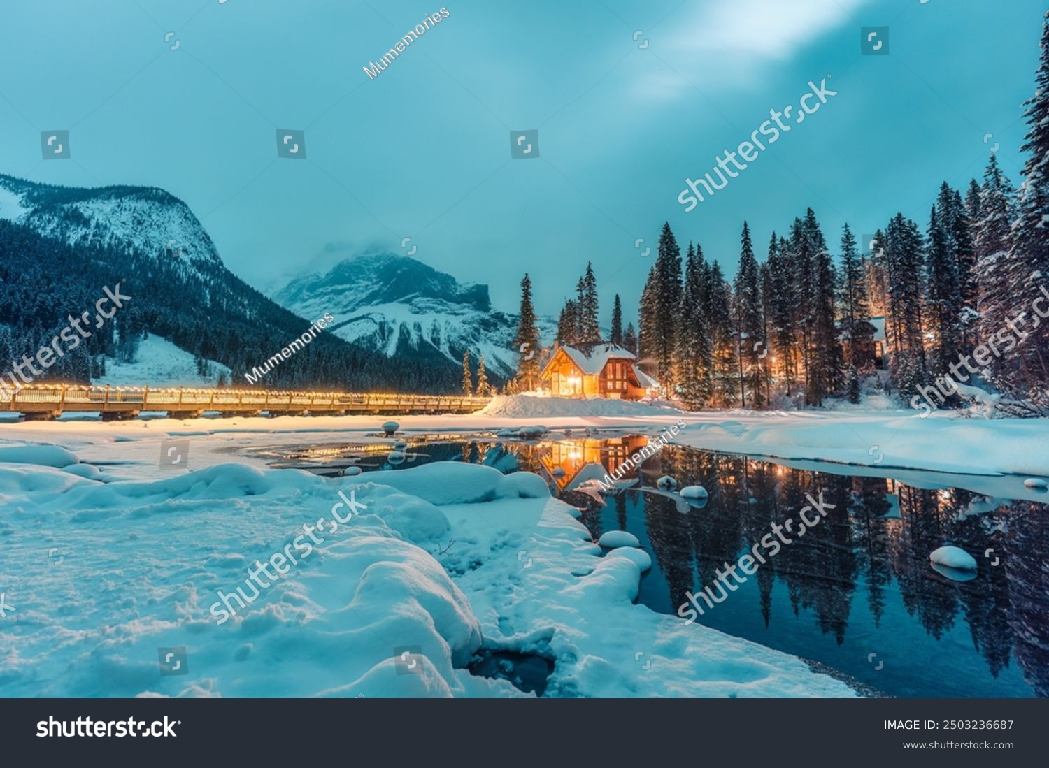 Beautiful winter scene of wooden lodge glowing on Emerald Lake and pine forest at Yoho national park  British Columbia  Canada