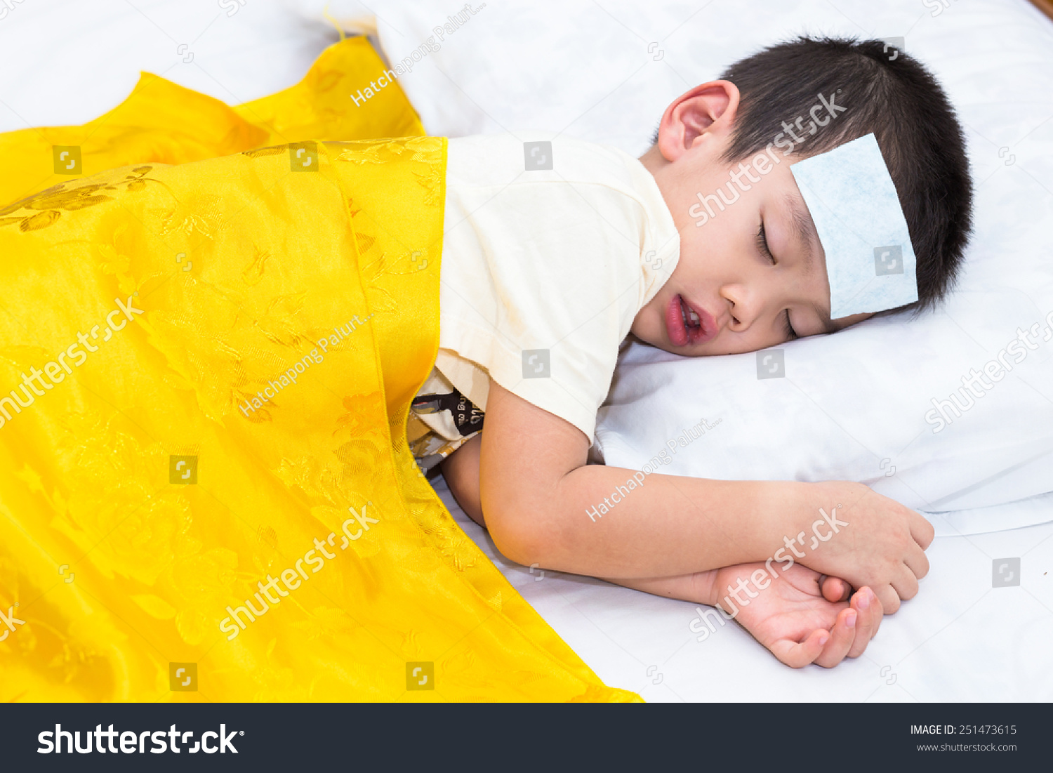 Little asian boy has fever and sleep on bed with gels fever on head