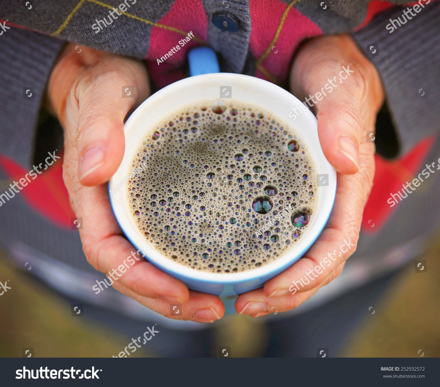  two hands keeping warm  holding a hot cup of tea or coffee 