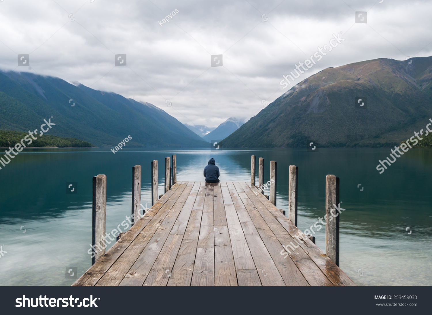 men sitting on a pier at Lake Nelson in New Zealand