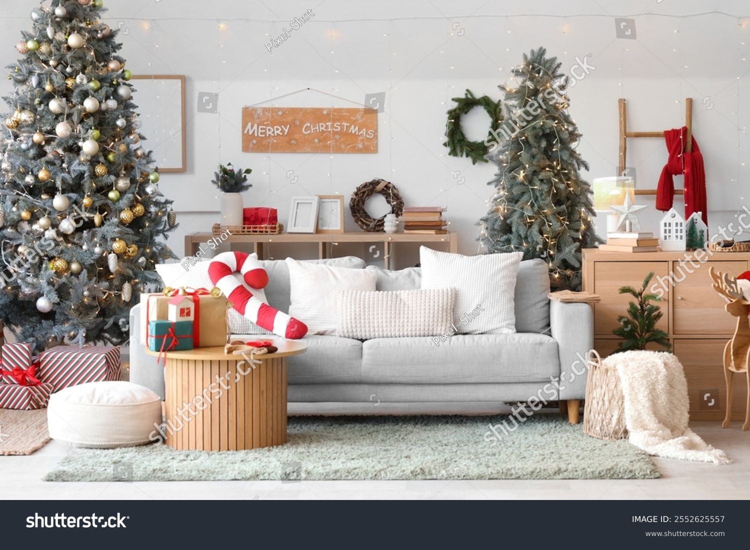 Interior of light living room with grey sofa Christmas tree and festive ...