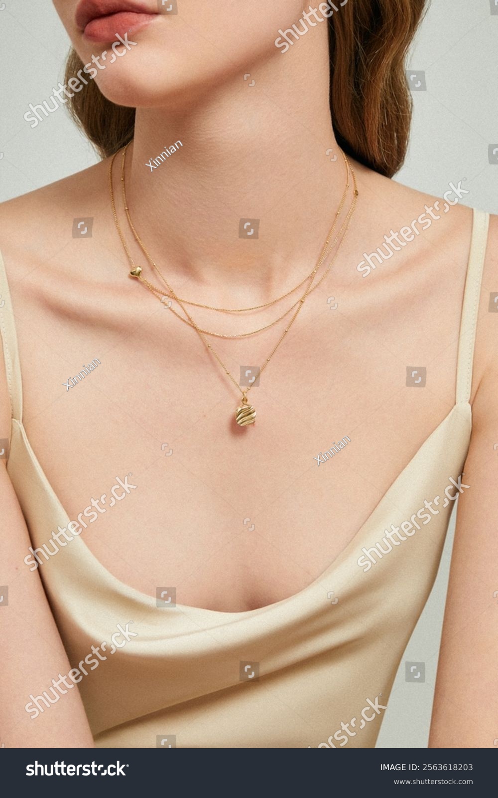 Elegant Woman Wearing Layered Gold Necklaces and Satin Slip Dress - Minimalist Jewelry Fashion for Modern Sophistication.
