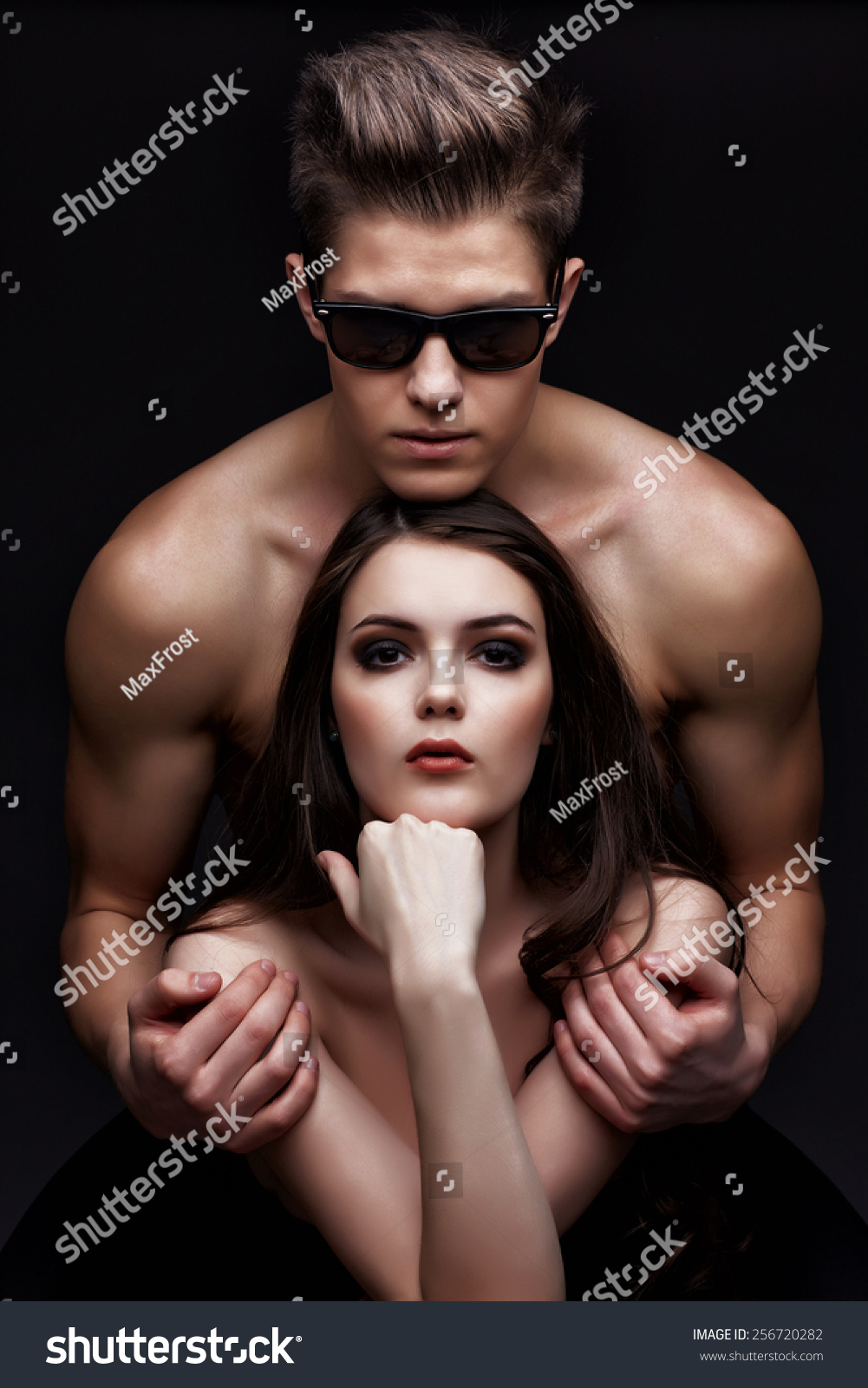 Sexy young couple in love. Studio shot on dark background