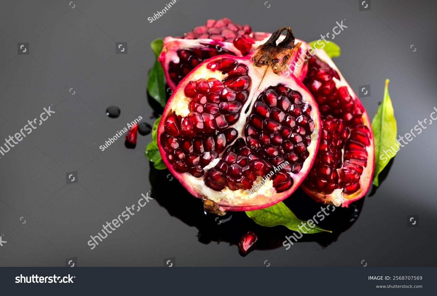 Pomegranate. Fresh juicy Pomegranates with leaves on a dark gray background. Organic Bio fruits closeup. Studio shot top view