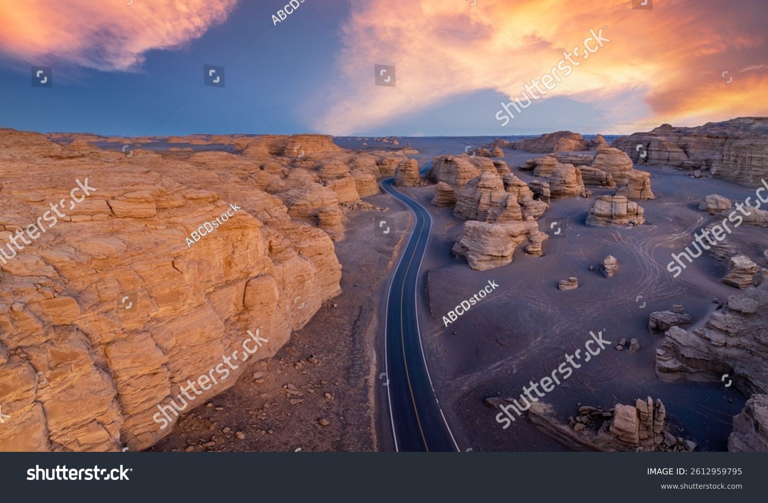 A road winding through the Yardang landform mountain at sunset. Famous Dahaidao no man's land natural landscape in Xinjiang  China.