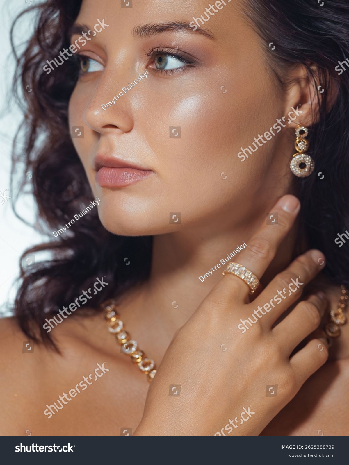 Refined close-up of a woman with glowing skin  wearing gold earrings  necklace  and a ring. High quality beauty and fashion image perfect for luxury jewelry or skincare promos.
