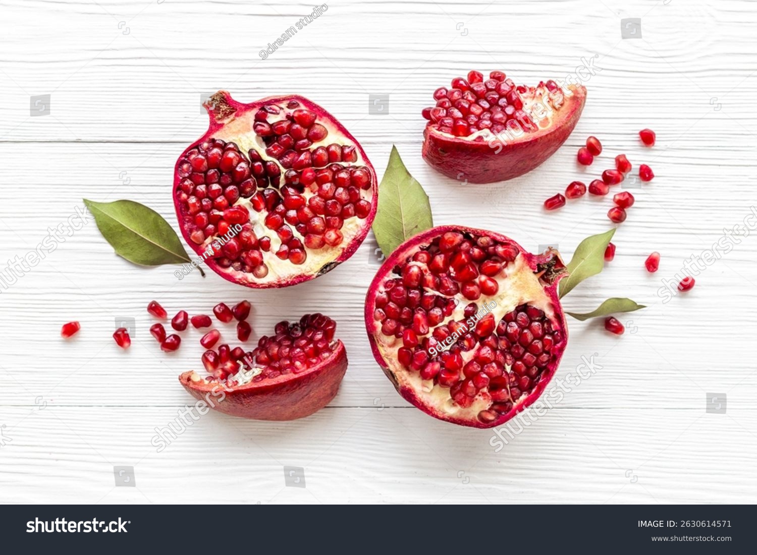 Top view of fresh ripe pomegranate with half and pieces ready for eating.