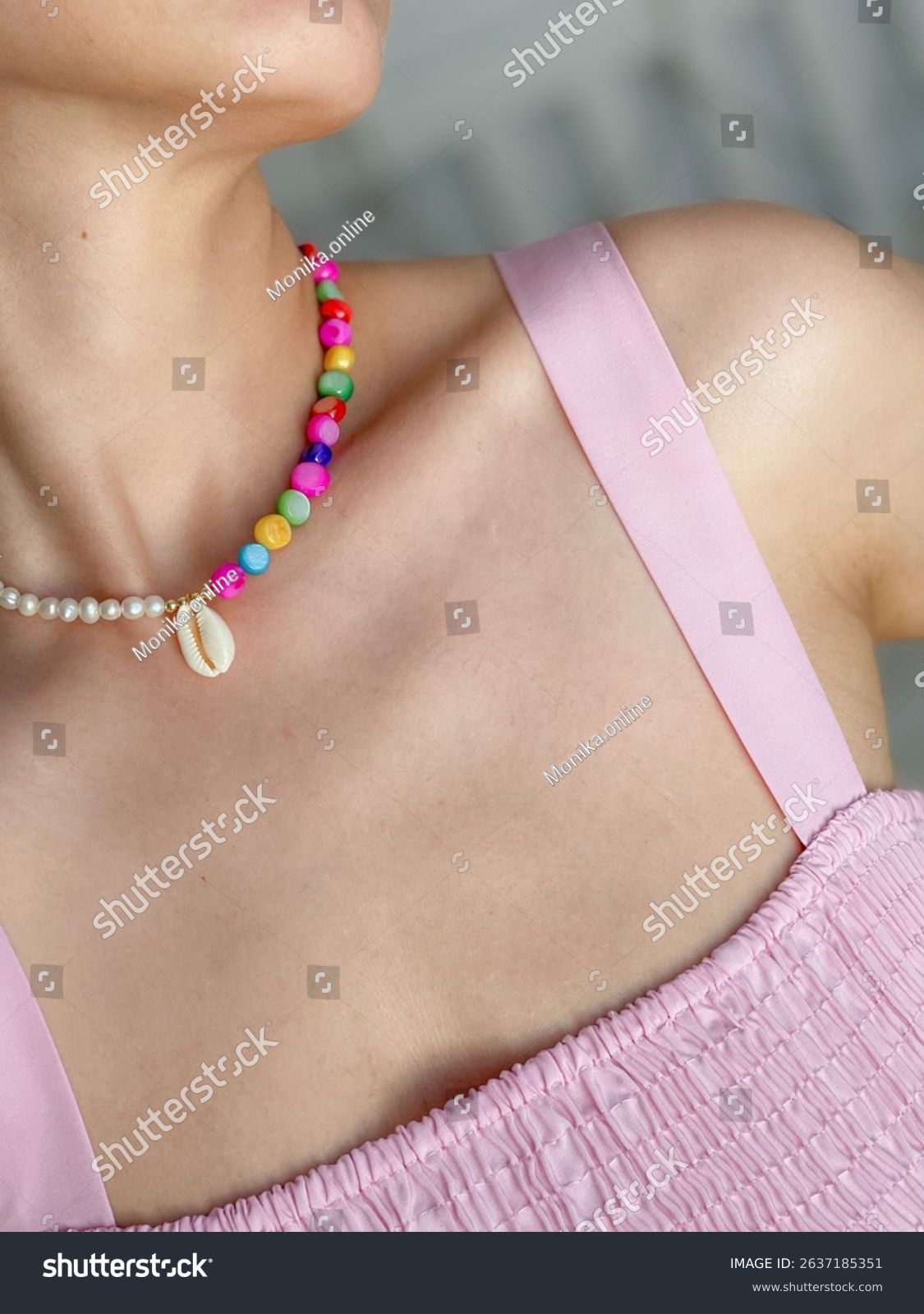Handmade necklace with pearls  shells and colorful stones on a woman's neck in a pink dress