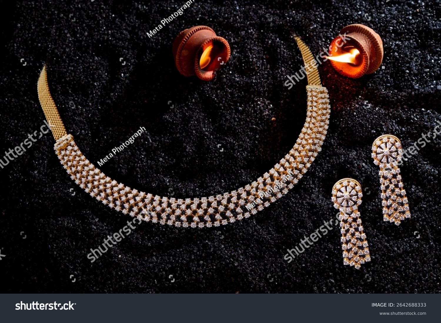 Elegant diamond-studded gold necklace set with matching long earrings  displayed on black textured background with glowing diyas  perfect for festive or bridal wear.