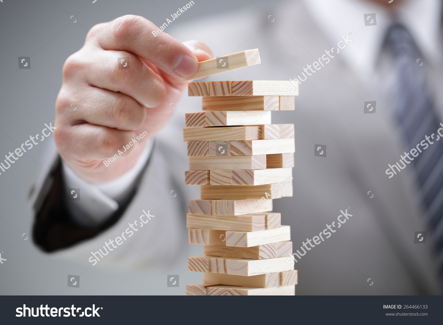 Planning  risk and strategy in business  businessman gambling placing wooden block on a tower