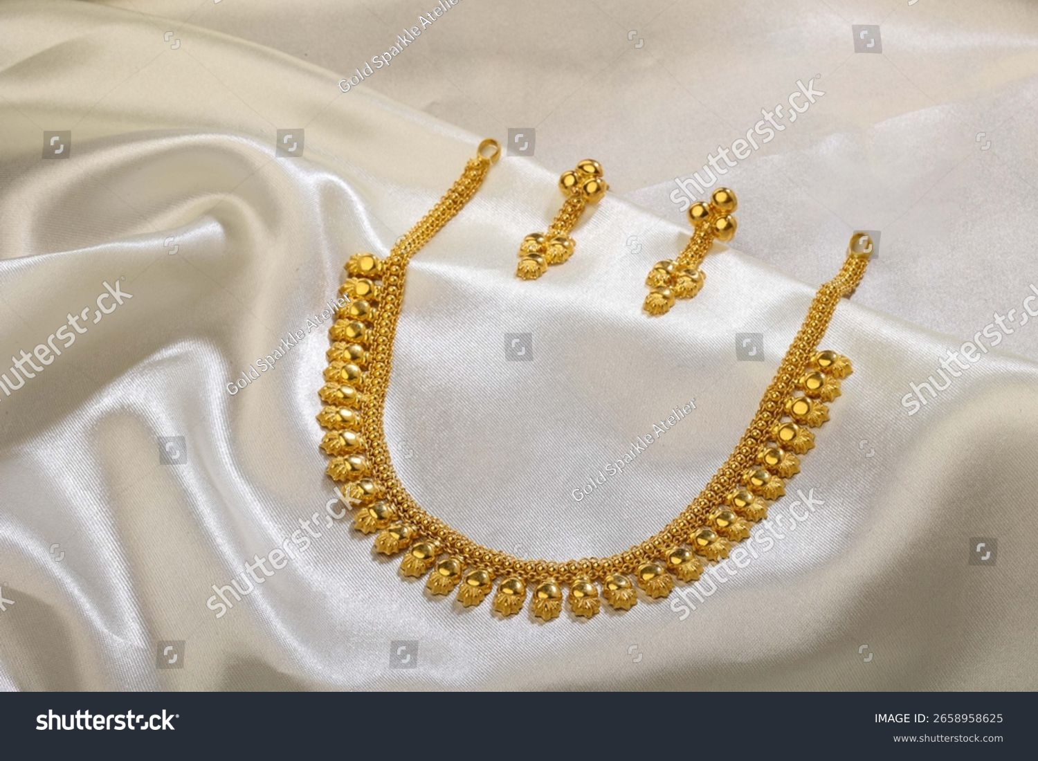 gold necklace on white satin background 