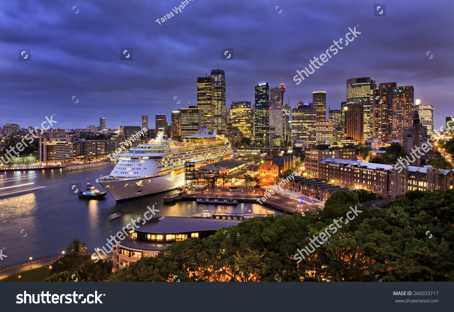 sydney harbour and city CBD at sunset with ocean liner at overseas terminal illuminated with lights