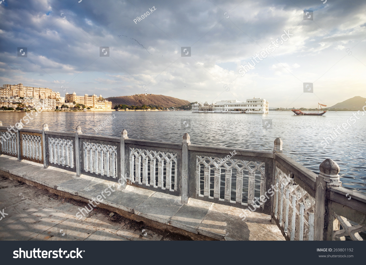 Lake Pichola with white palace in the center at cloudy sky in Udaipur  Rajasthan  India