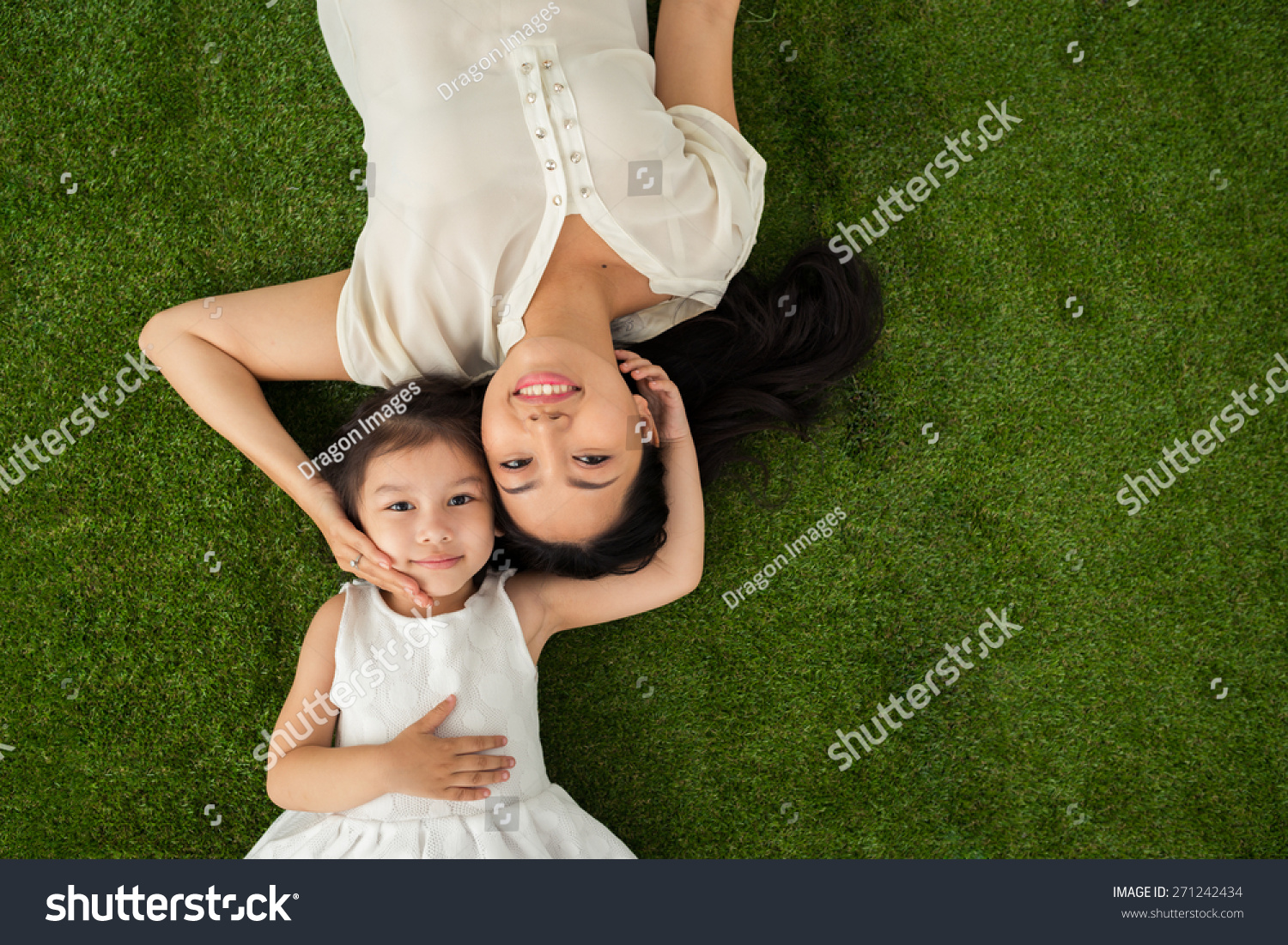 Happy family of two lying on the grass  view from above