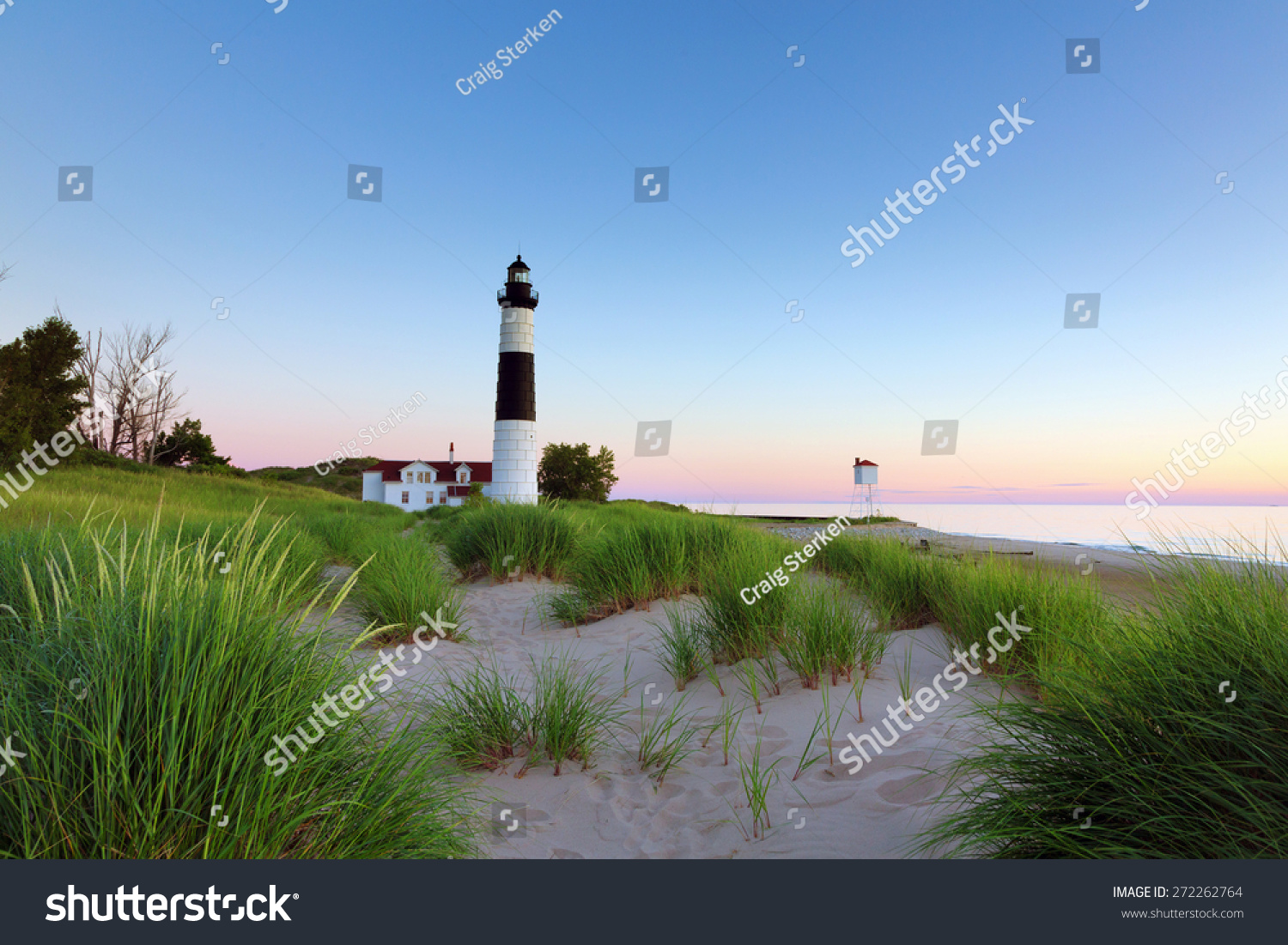 Big Sable Point Lighthouse in Ludington State Park on a Lake Michigan beach. Sunset hues in the background.